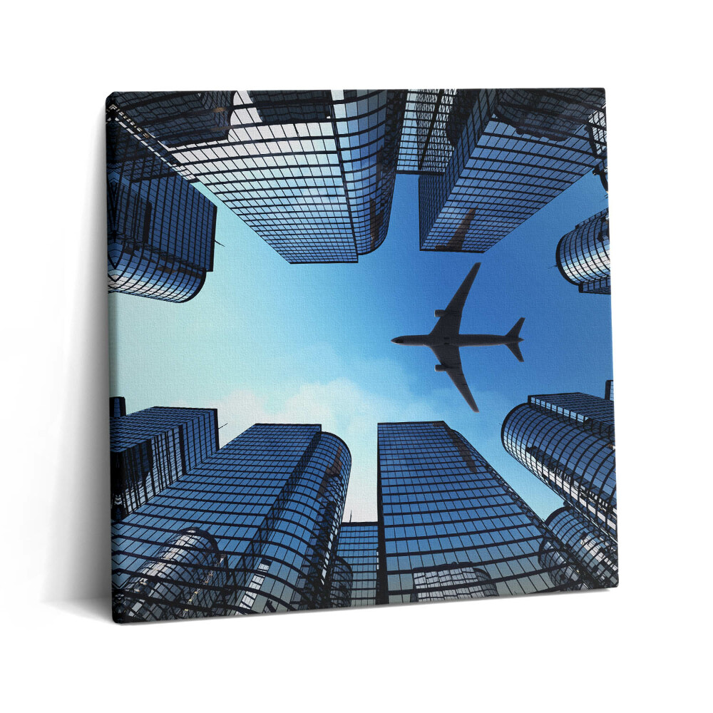 Tablou pe pânză canvas 60x60 Avion deasupra clădirilor